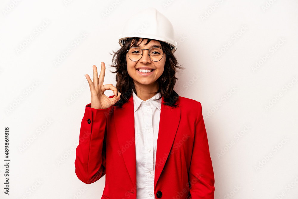 Young architect hispanic woman with helmet isolated on white background cheerful and confident showing ok gesture. Young architect hispanic woman with helmet isolated on white background cheerful and confident showing ok gesture.