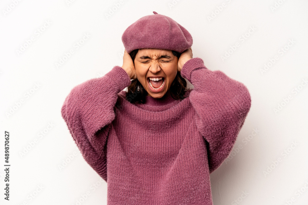 Young hispanic woman isolated on white background covering ears with hands trying not to hear too loud sound. Young hispanic woman isolated on white background covering ears with hands trying not to hear too loud sound.