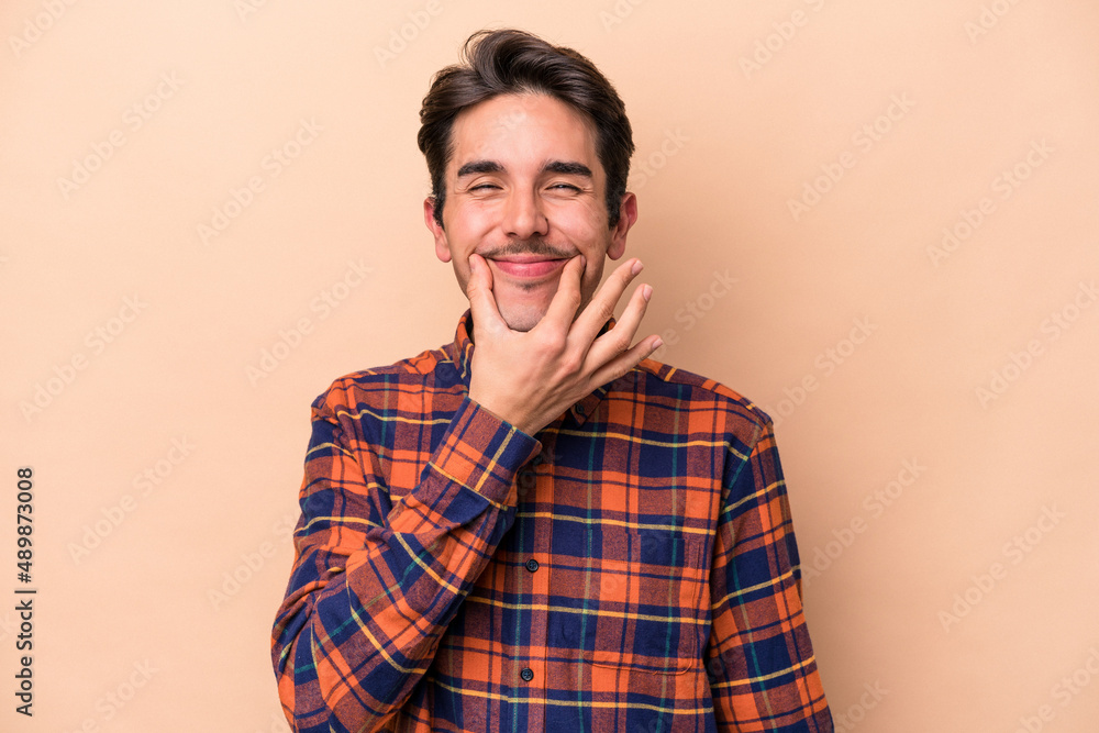 Young caucasian man isolated on beige background doubting between two options. Young caucasian man isolated on beige background doubting between two options.