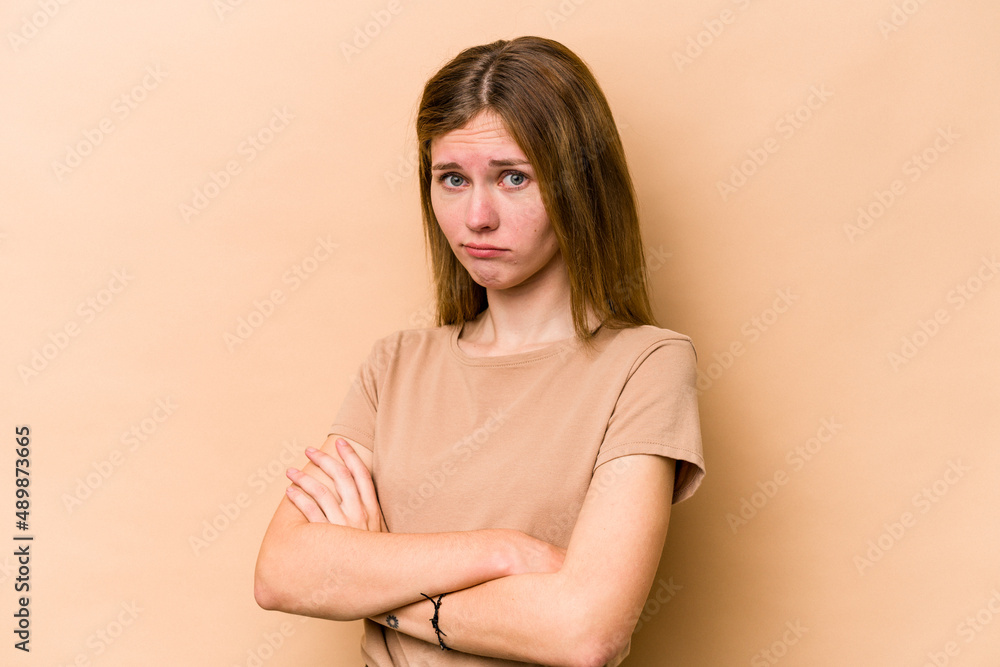 Young English woman isolated on beige background suspicious, uncertain, examining you. Young English woman isolated on beige background suspicious, uncertain, examining you.