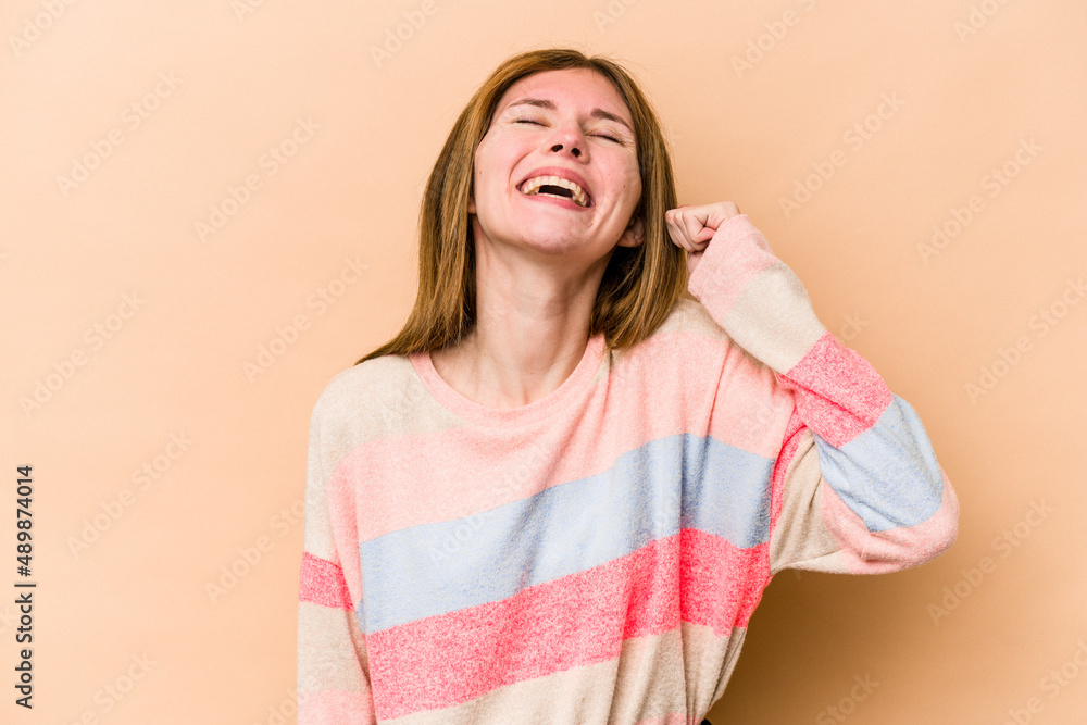 Young English woman isolated on beige background celebrating a victory, passion and enthusiasm, happy expression. Young English woman isolated on beige background celebrating a victory, passion and enthusiasm, happy expression.