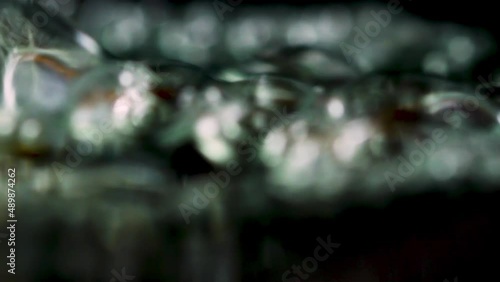 Close up of boiling wayer with moving air bubbles on a black background. Stock footage. Concept of cooking or making hot beverage. photo