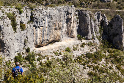 Falaise d'escalade avec personne observant les préparatifs d'une cordée. Gorge d'Oppedette, Parc naturel régional du Luberon