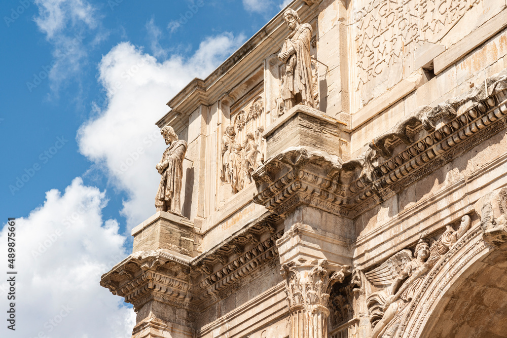 detail of the Arch of Constantine on a sunny day with clouds