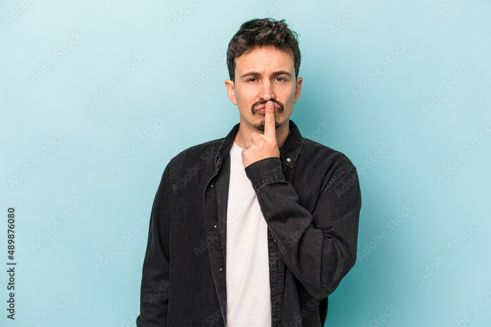 Young caucasian man isolated on blue background thinking and looking up, being reflective, contemplating, having a fantasy. Young caucasian man isolated on blue background thinking and looking up, being reflective, contemplating, having a fantasy.