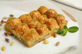 Delicious sweet baklava with pistachios and mint on board, closeup