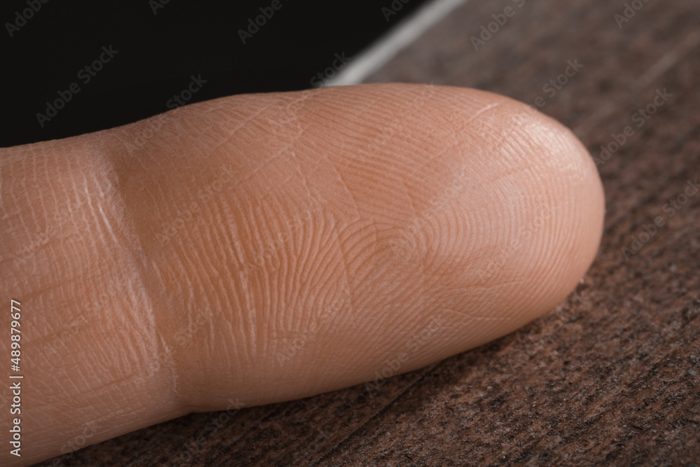 Closeup view of human finger on wooden surface Closeup view of human finger on wooden surface