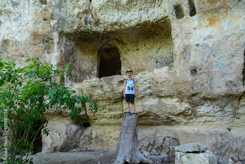 A little boy in the caves of the city of Tepe-Kermen in Bakhchisarai. Crimea. Russia. Crimean mountains. 2021