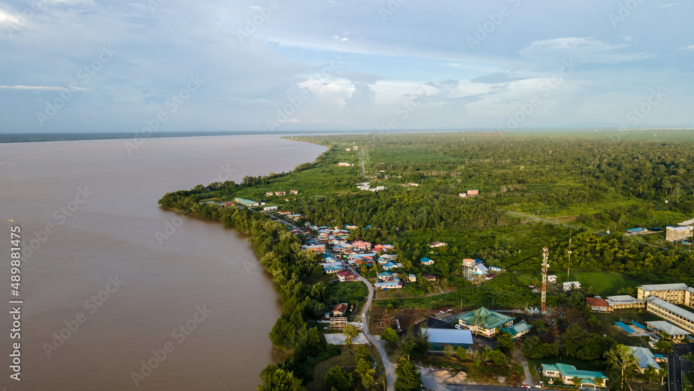 Aerial view of village at riverbank in rural area.