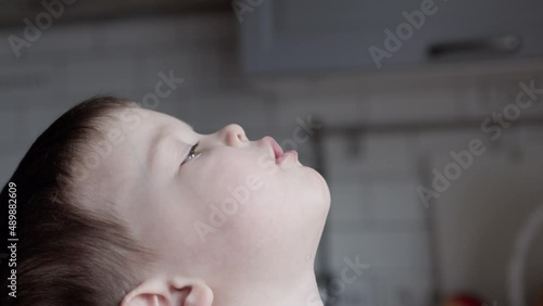 portrait caucasian baby boy child gargling sore throat with medicine, gargle kid close-up view. home treatment children disease. flu cold, infection