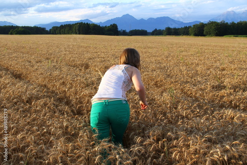 Lonely woman in the ripe barley field. Absorbing sun energy.