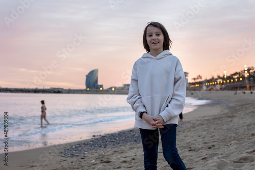 Cute little child tourists, admiring the beach Barcelona city, family travel with kids
