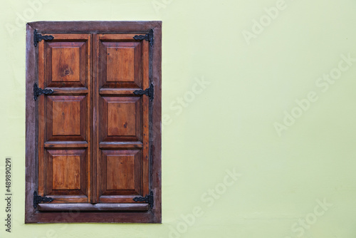 Close-up wall of a stone house with wooden windows and shutters. Old european architecture