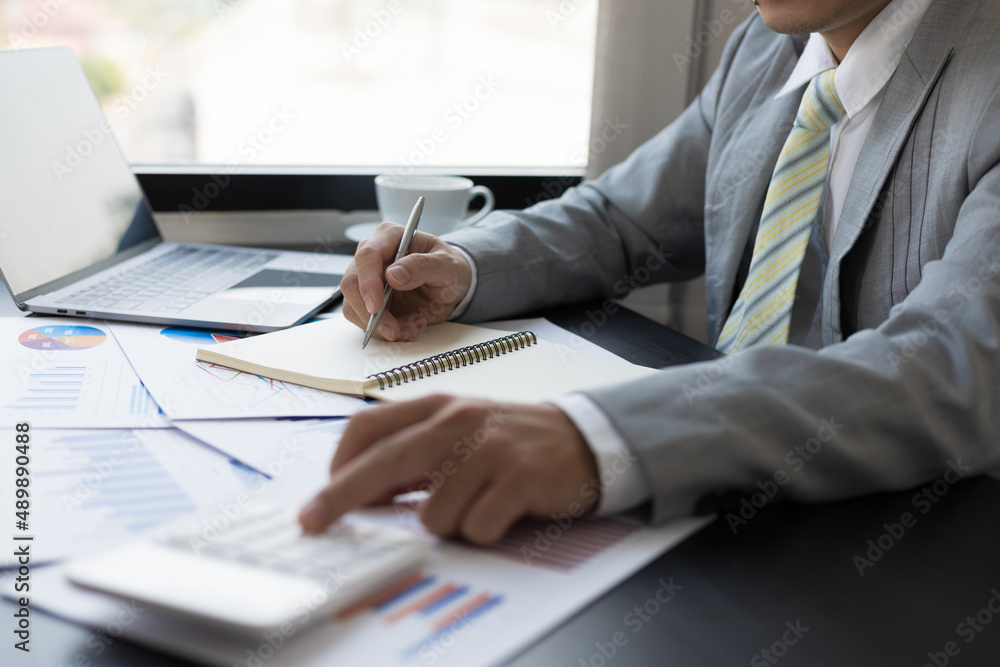 Accountant man hand press on calculator and writing a note for make financial report or company's profit annual at desk, bookkeeper job. Accountant man hand press on calculator and writing a note for make financial report or company's profit annual at desk, bookkeeper job.
