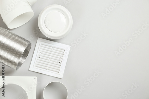 Parts of home ventilation system on light grey background, flat lay. Space for text photo