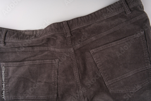 The back of dark corduroy trousers. Pockets are visible. Close