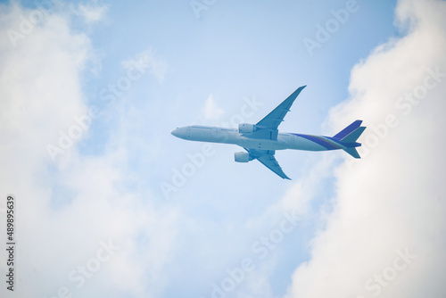 Close-up aircraft flying against cloudy sky.