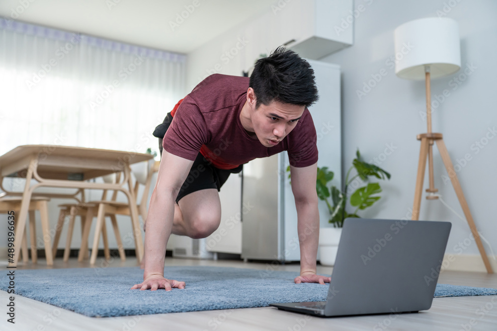 Asian handsome active young man doing exercise on floor in living room