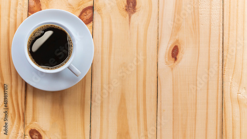Coffee Mug on Wooden Table. Top view cup of coffee on wooden table. Close up hot coffe in white cup on wood table.
