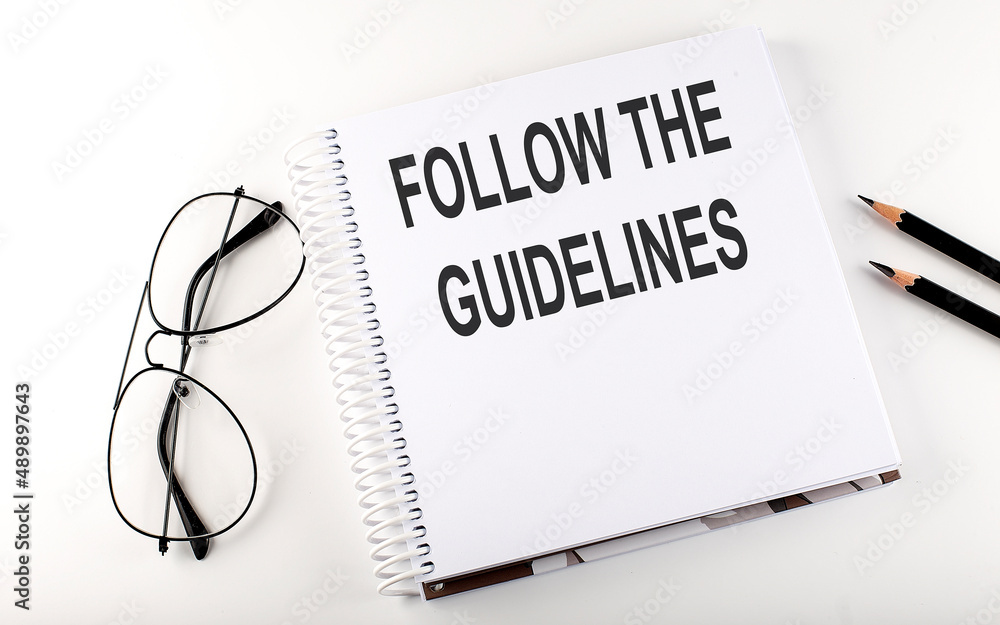 Notebook with text FOLLOW THE GUIDELINES on the white background Notebook with text FOLLOW THE GUIDELINES on the white background
