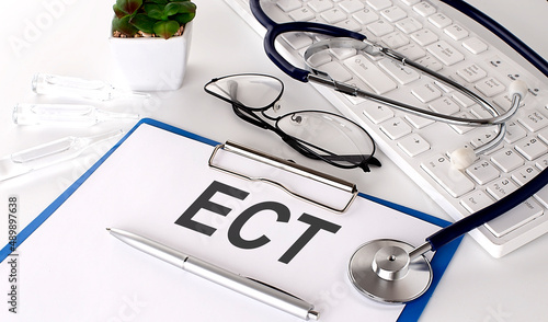 ECT text on white paper on white background. stethoscope ,glasses and keyboard photo