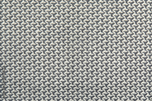 Knitted texture. Texture of jacquard fabric with gray geometric pattern. Crochet mosaic pattern.