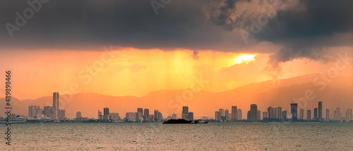 Beautiful scenery of a city skyline on a sunset with dramatic clouds of rain and storm
