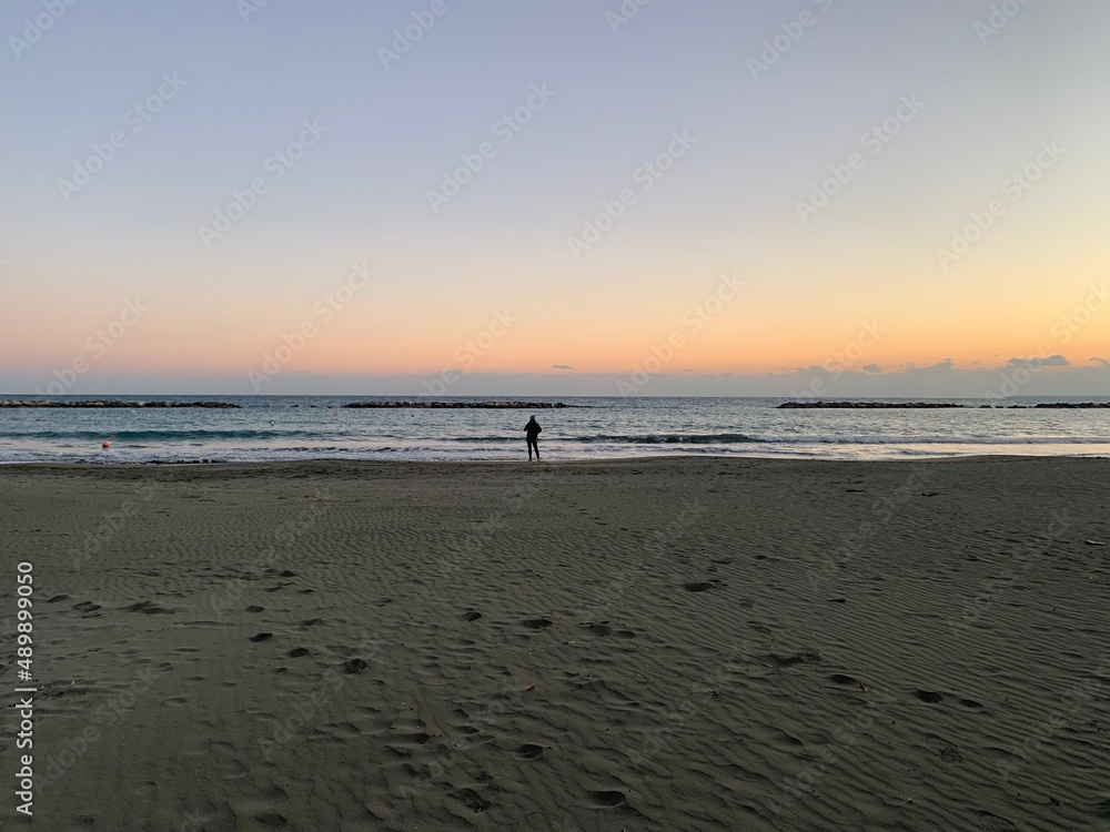 Small human silhouette by the sea, evening time 