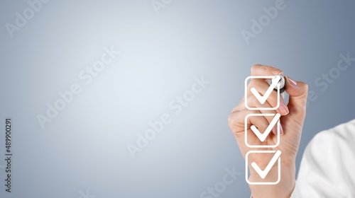 Photography Young man checking boxes with list on background