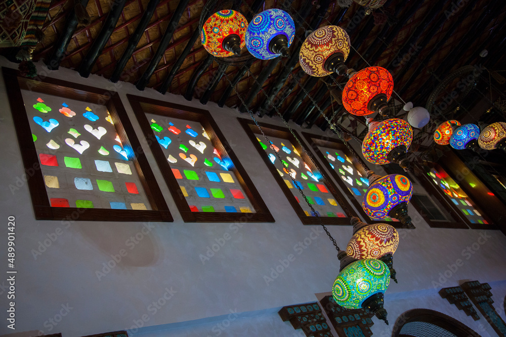 Fototapeta premium Doha,Qatar-May 05 2019: In the Old market Souk Waqif a decorative, traditional, glass mosaic lamps hanging.