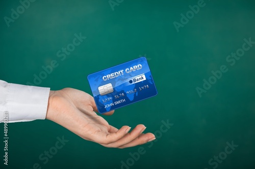 Human hand holds levitating template mockup Bank credit card with online service