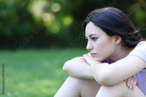 Sad asian woman complaining looking away in a park