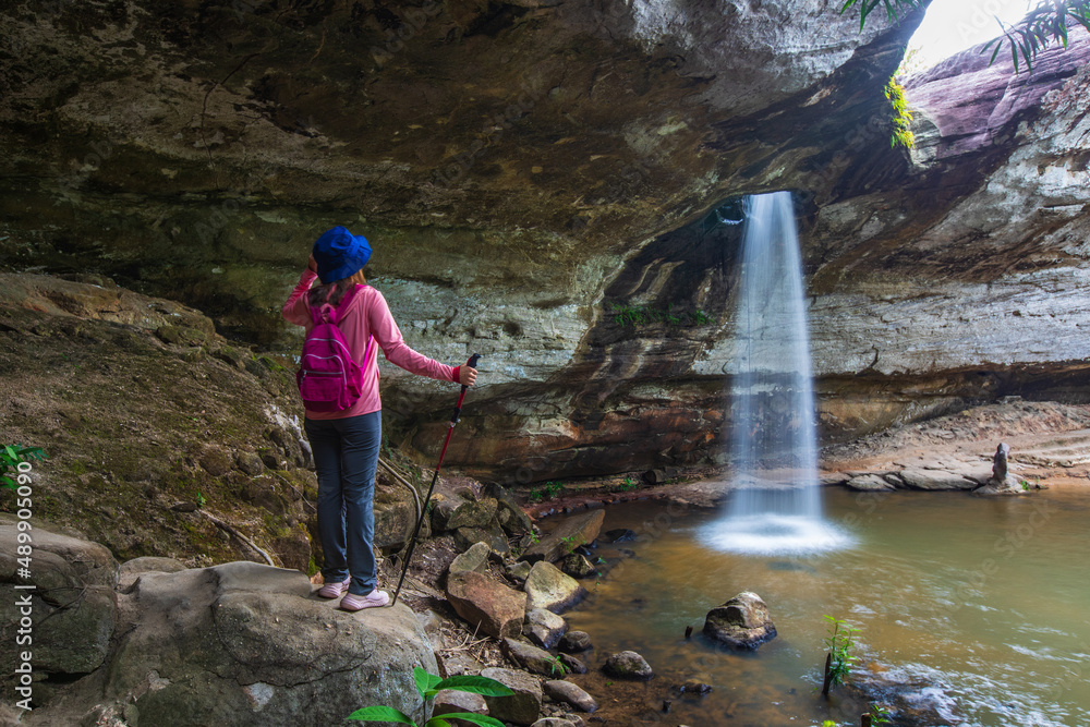Obraz premium Young woman hiking in Sang Chan Waterfall, Beautiful waterfall in Pha Tam national Park, Ubon Ratchathani province, ThaiLand.