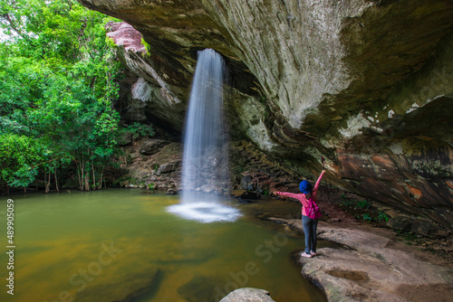 Young woman hiking in Sang Chan Waterfall  Beautiful waterfall in Pha Tam national Park  Ubon Ratchathani  province  ThaiLand.