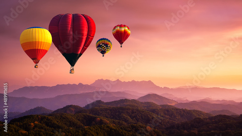Hot air balloon above high mountain at sunrise, sunset. View of mountain with hot air balloons on morning at Thailand.