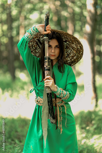 the girl is in the forest in a vietnamese hat