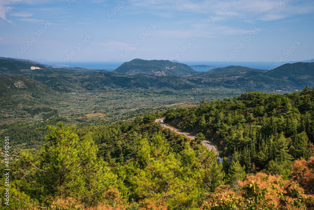 The road on island of Lefkada among forests and mountains in background
