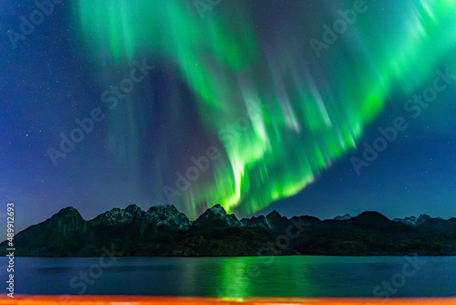 Nordlichter im Raftsund zwischen den Lofoten und den Vesteralen. Über den verschneiten Bergen tanzt die Aurora Borealis am sternenklaren Himmel! Grün, Weiss, Pink und Hellblau leuchtet das Nordlicht. photo
