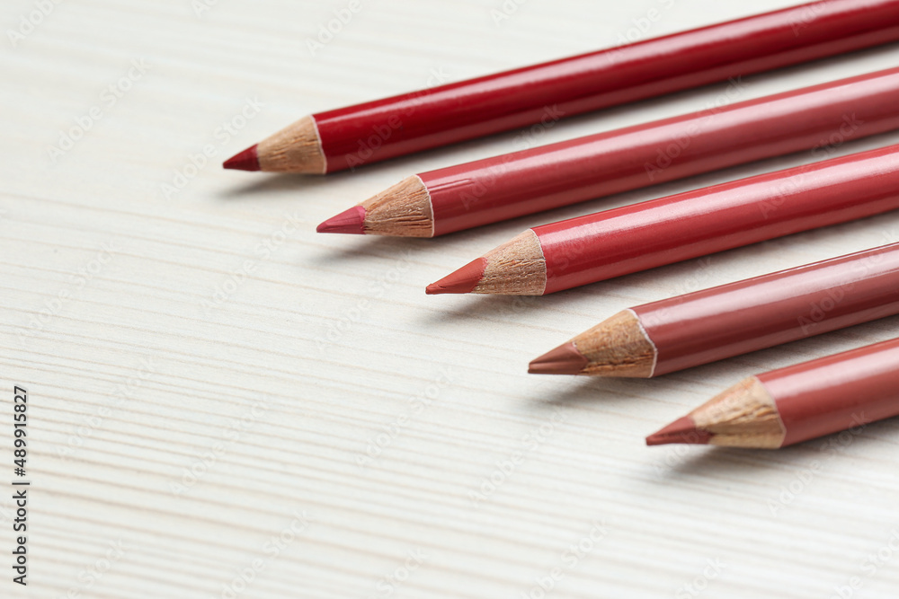Many lip pencils on white wooden table, space for text Many lip pencils on white wooden table, space for text