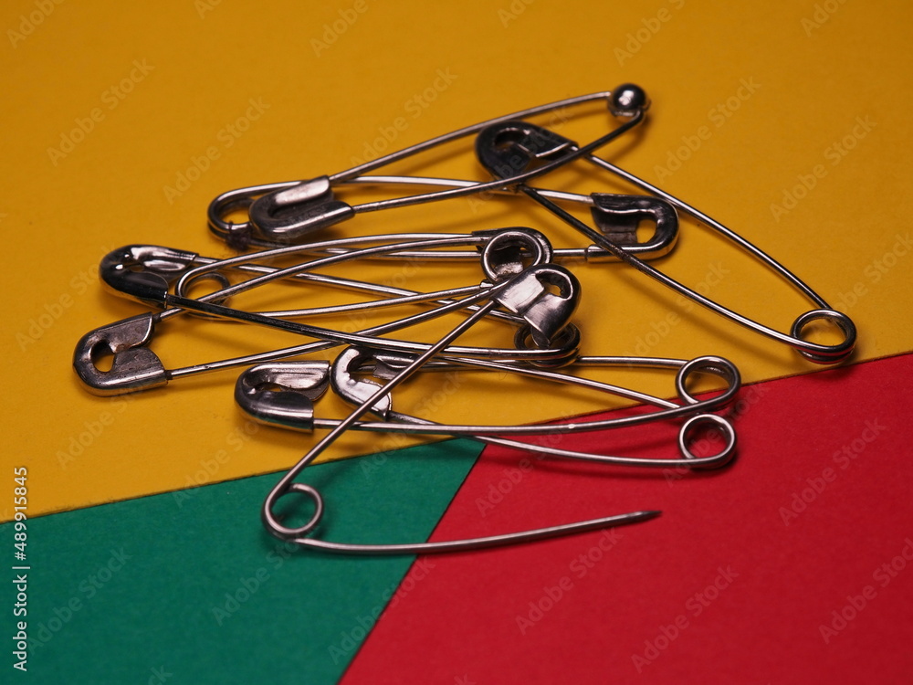 Fototapeta premium Safety pins on a colored background. Safety pin for help close or temporarily mend damaged clothes.