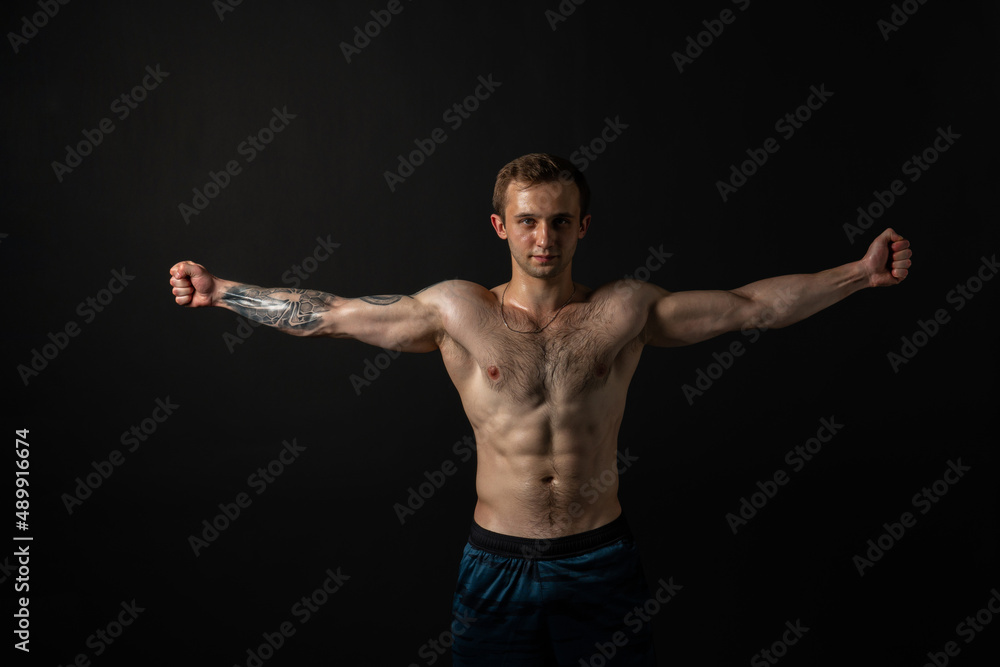 Man on black background keeps dumbbells pumped up in fitness muscle sexy body muscular man athletic dumbbell, male pectoral. Attractive handsome adult, one fit
