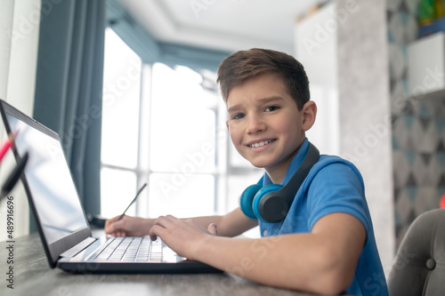 Joyous kid posing for the camera during his online lesson Free Download Joyous kid posing for the camera during his online lesson - GFXLoad