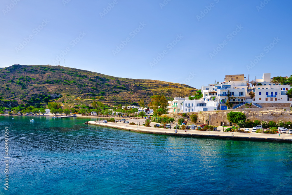 Beautiful summer day, sunshine in typical town of Greek island. Whitewashed houses on hills. Mediterranean vacations. Milos, Cyclades, Greece.