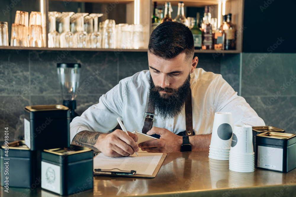 Barista Doing an Inventory of the Products and Writing Notes on a ...