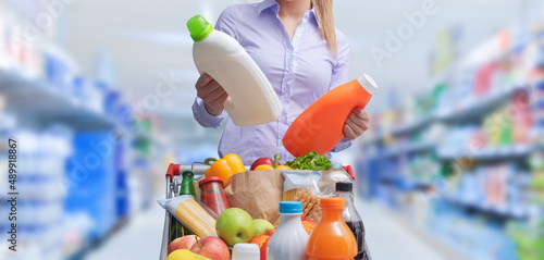 Fotografia Woman comparing products at the supermarket