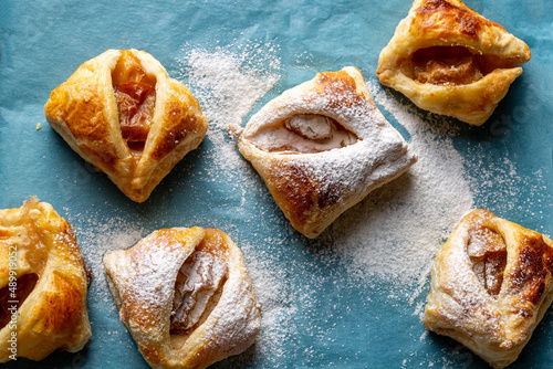 puff pastry cookies with frozen plums on blue paper photo