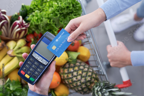 Woman paying for groceries using a credit card photo