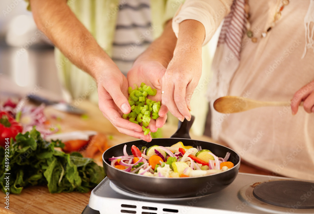 Many hands make light work. Cropped image of a married couple cooking in the kitchen. Many hands make light work. Cropped image of a married couple cooking in the kitchen.