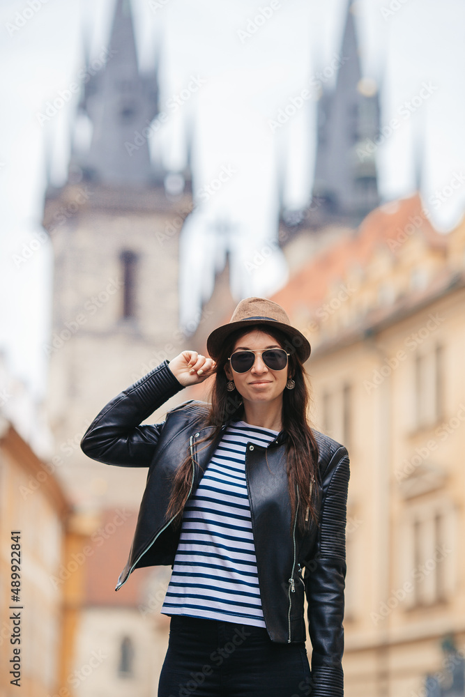 Fototapeta premium Happy young woman in hat on the street of european city.