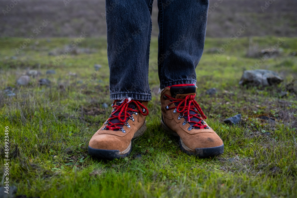 Detail of hiking boots in green grass on cold damp morning Detail of hiking boots in green grass on cold damp morning